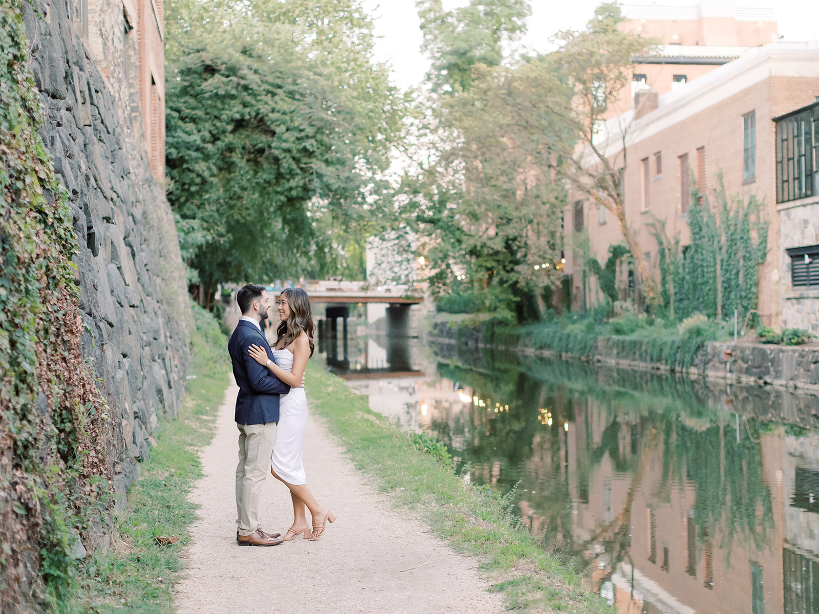 Couple posing in the C&O Canal in Georgetown with moss covered walls.